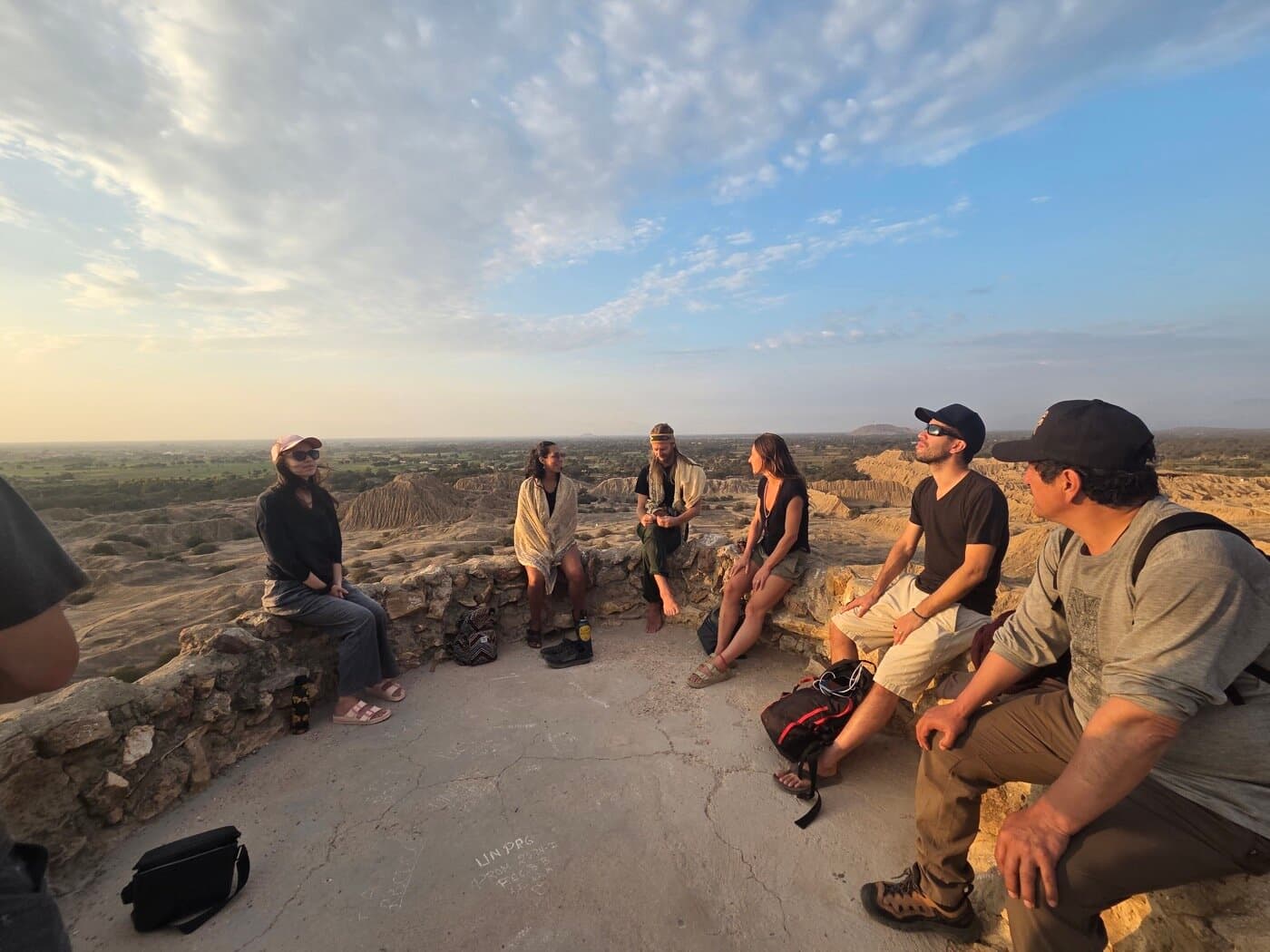 Sacred Ways group in conversation circle on the Batán Grande overlook at sunset